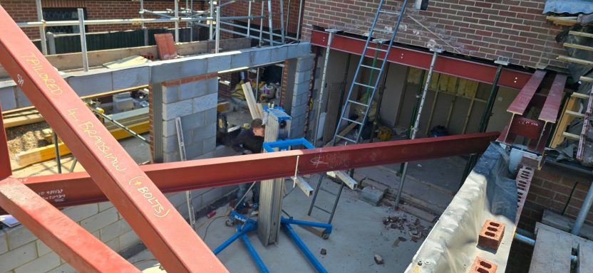Red oxide primed RSJ being lifted into place on a house extension, Norfolk