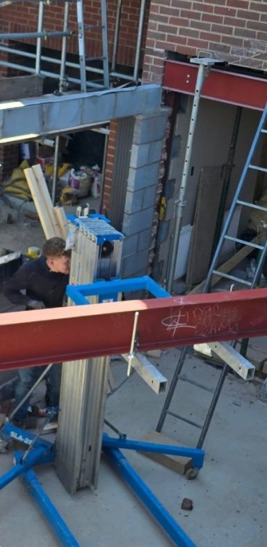 Red oxide primed RSJ being lifted into place on a house extension, Norfolk