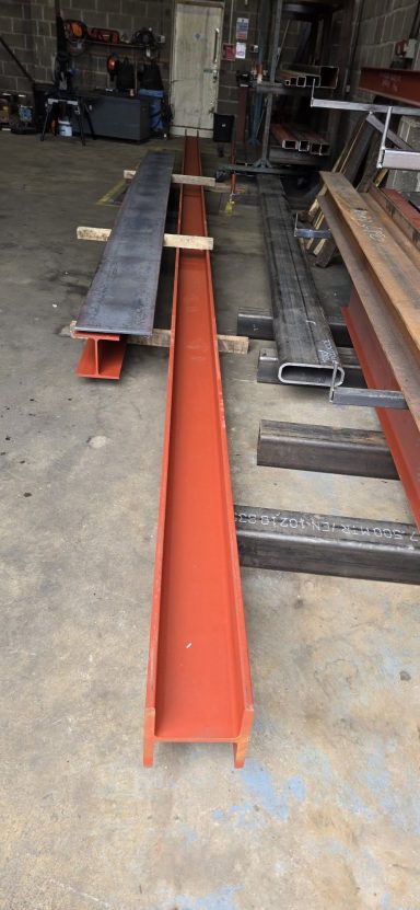 Red primed steel channel beam on the workshop floor, Rackheath, Norwich